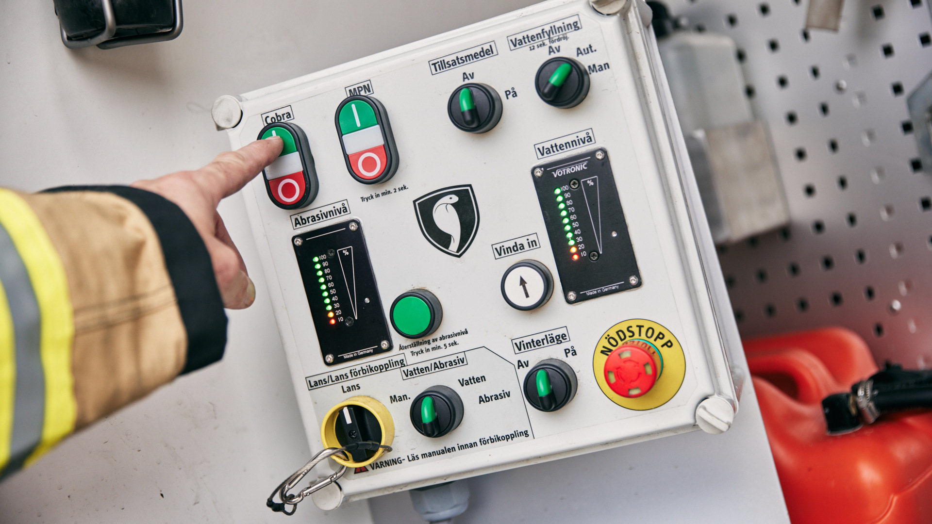 A fireman's hand is on a control panel